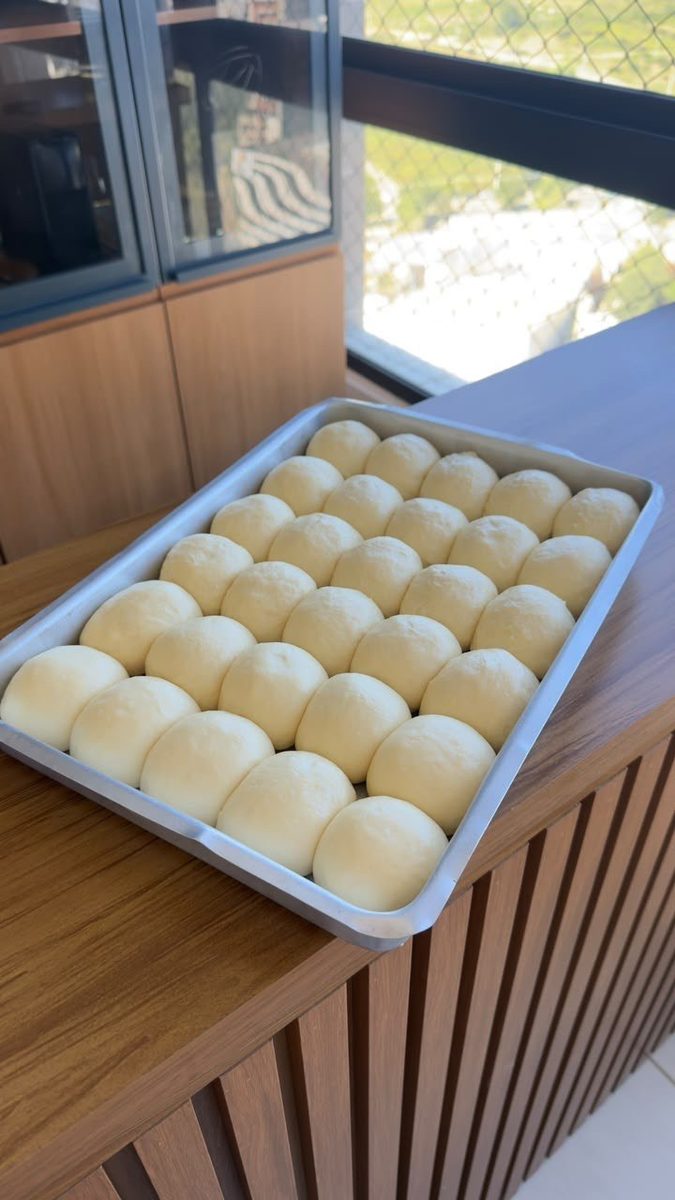 Bandeja de pãezinhos boleados e crescidos, prontos para assar